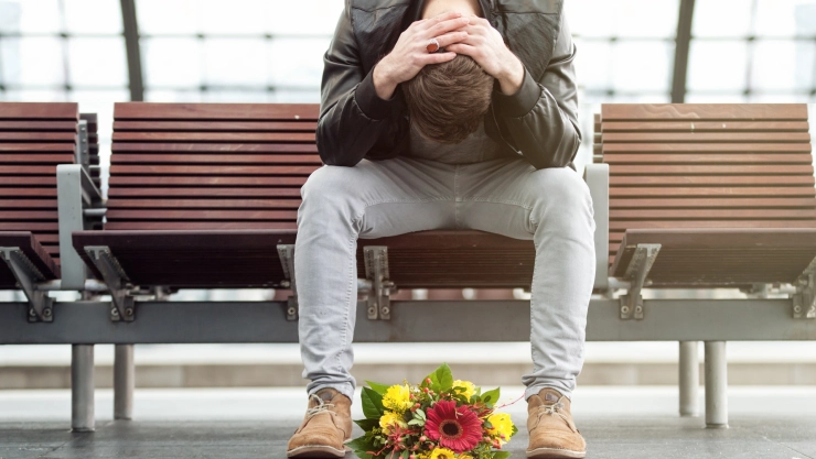 Un hombre espera con flores a su pareja