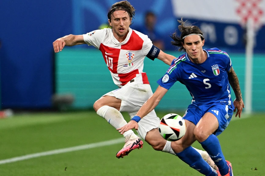 Luka Modric ante el defensa italiano Riccardo Calafiori