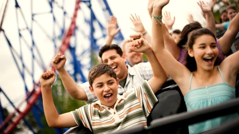 una familia feliz disfruta de una montaña rusa