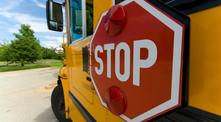 Un bus escolar con un cartel para parar