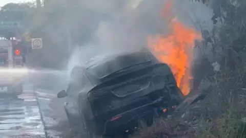 ¡Vaya accidente! Tesla se cae de puente en Puerto Aventuras y se incendia en la vía.jpg
