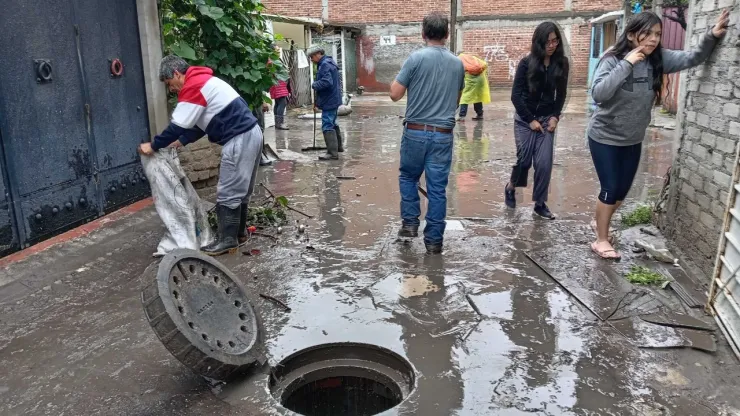 Vecinos realizan labores de limpieza tras desbordamiento de la presa Los Cuartos en Naucalpan, Edomex.