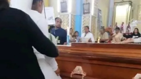 Mujer vestida de novia en funeral de su prometido