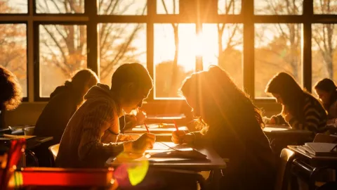 Una foto de un aula iluminada por el sol que muestra los cálidos rayos del sol que entran a través de las ventanas