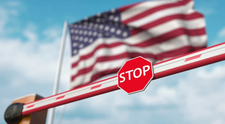 Una bandera estadounidense frente a una señal de Stop.
