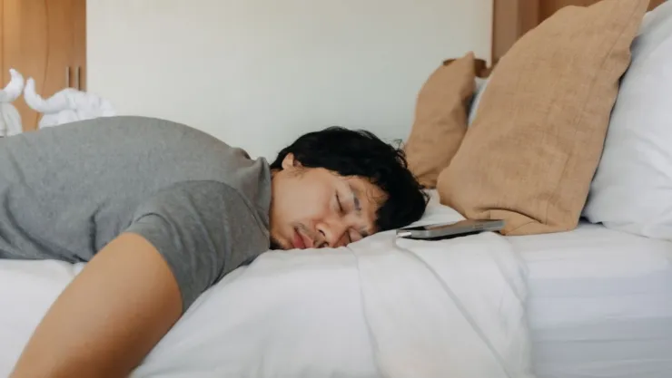 Un hombre descansa sobre su cama.