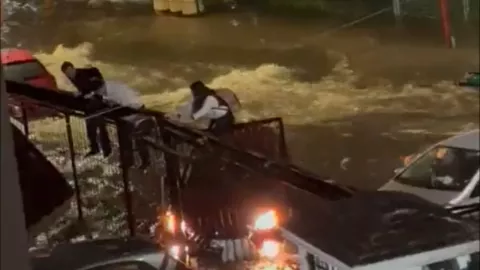Jóvenes se suben al cancel para salvarse de la inundación en Guadalajara