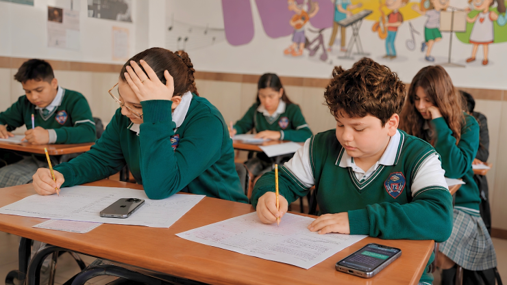 Estudiantes en el salón de clases usando IA