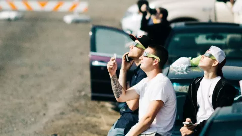 Un grupo de personas en Estados Unidos viendo el eclipse solar del 2017 con lentes para eclipse