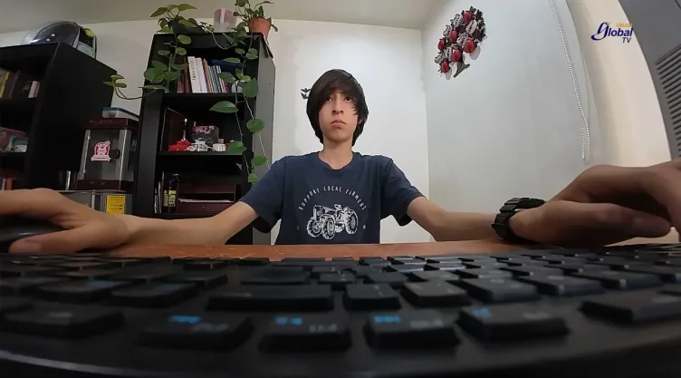 aspirante de la UNAM realizando su examen de admisión del bachillerato frente a una computadora.