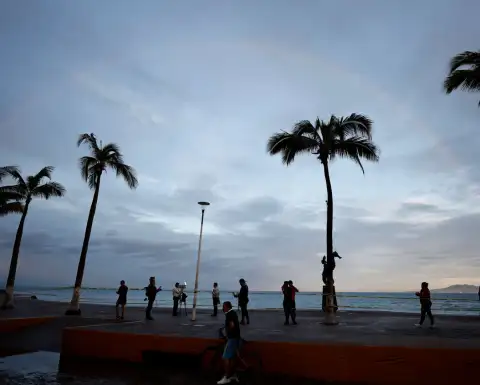 Personas frente a una playa en Puerto Vallarta tras el paso del huracán Simón.