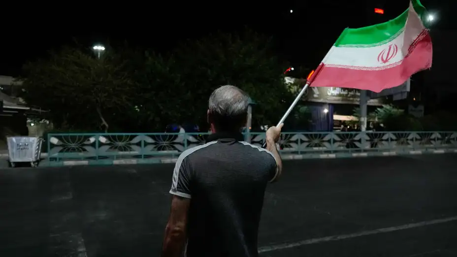 Una persona la bandera iraní en Teherán.
