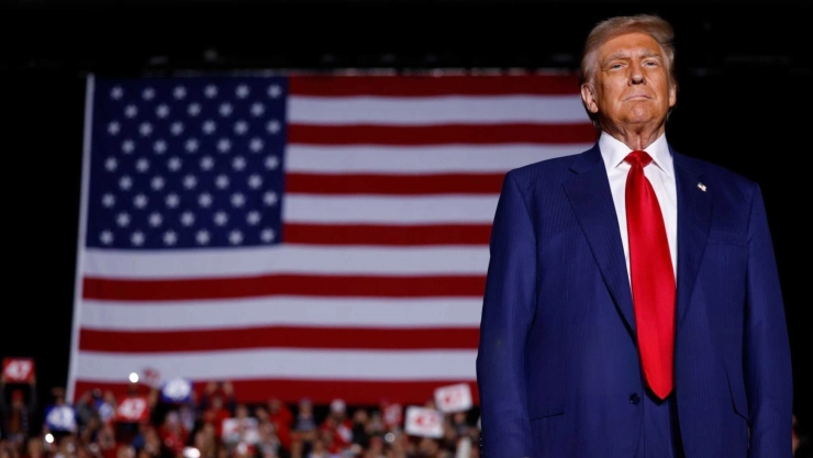 El presidente electo Donald Trump frente a una bandera estadounidense.