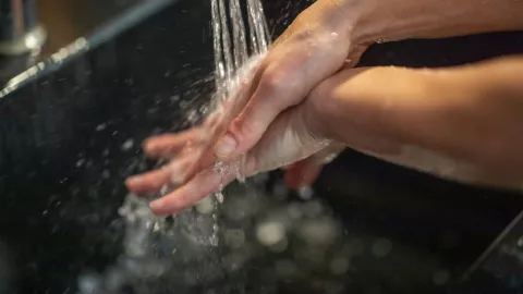 An adult washing her hands to prevent the spreading of Clovid-19.