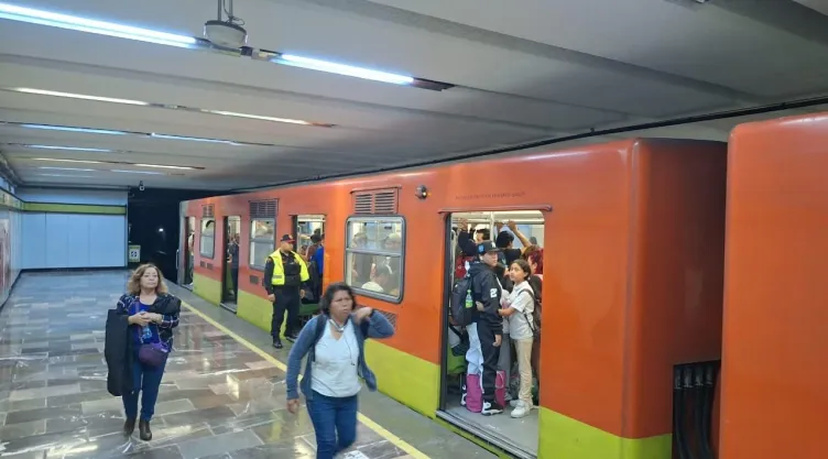 Personas caminando en el metro CDMX por retraso de trenes.