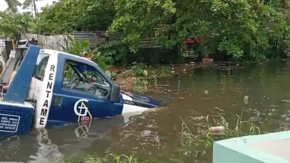 Grua cae a canal en Coatzacoalcos por lluvias.