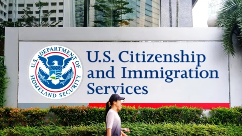 Fachada del USCIS con dos personas caminando