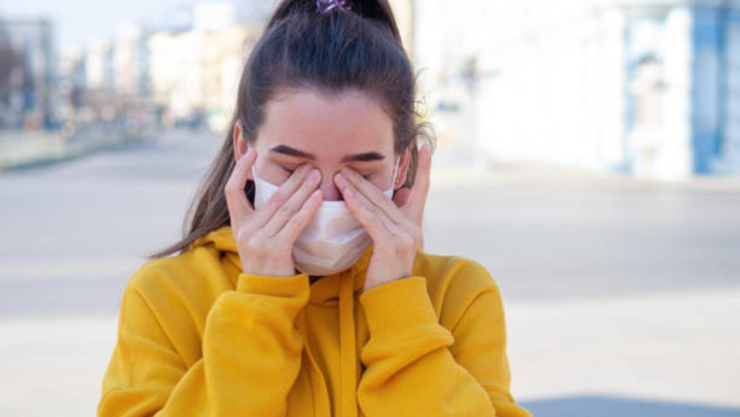 mujer con covid-19 tallándose los ojos.jpg