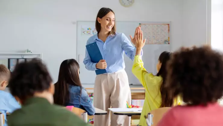 una profesora choca los cinco con su alumna