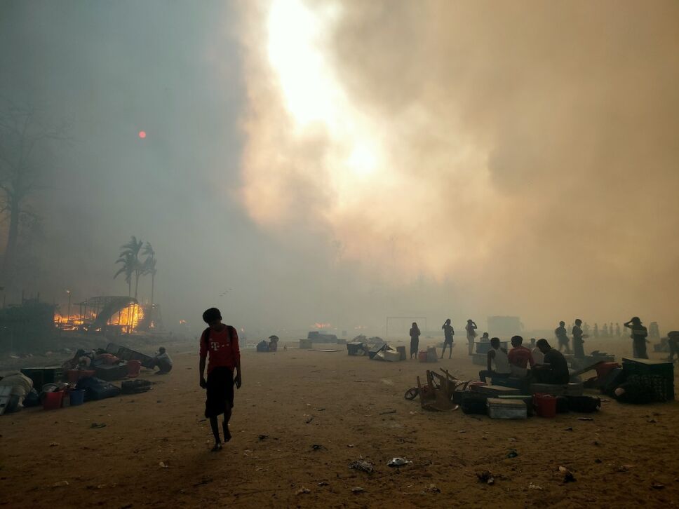 hombre caminando por el campo de refugiados rohingya tras el incendio
