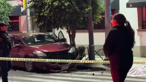 Mientras Dormía_ Muere mujer atropellada tras choque; volvía del trabajo y el conductor iba ebrio. En la imagen se obderva uno de los autos accidentados junto al cuerpo de la víctima que se encuentra sobre el pavimento.