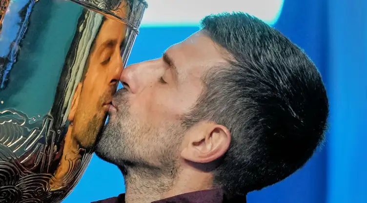 Novak Djokovic besa el trofeo de campeón del Abierto de China.