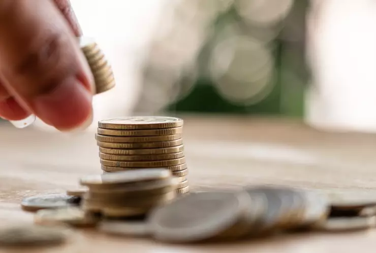 una mujer recoge monedas de una mesa