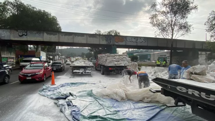 Trabajadores apoyan a la limpieza de bultos de cal sobre la autopista México-Pachuca