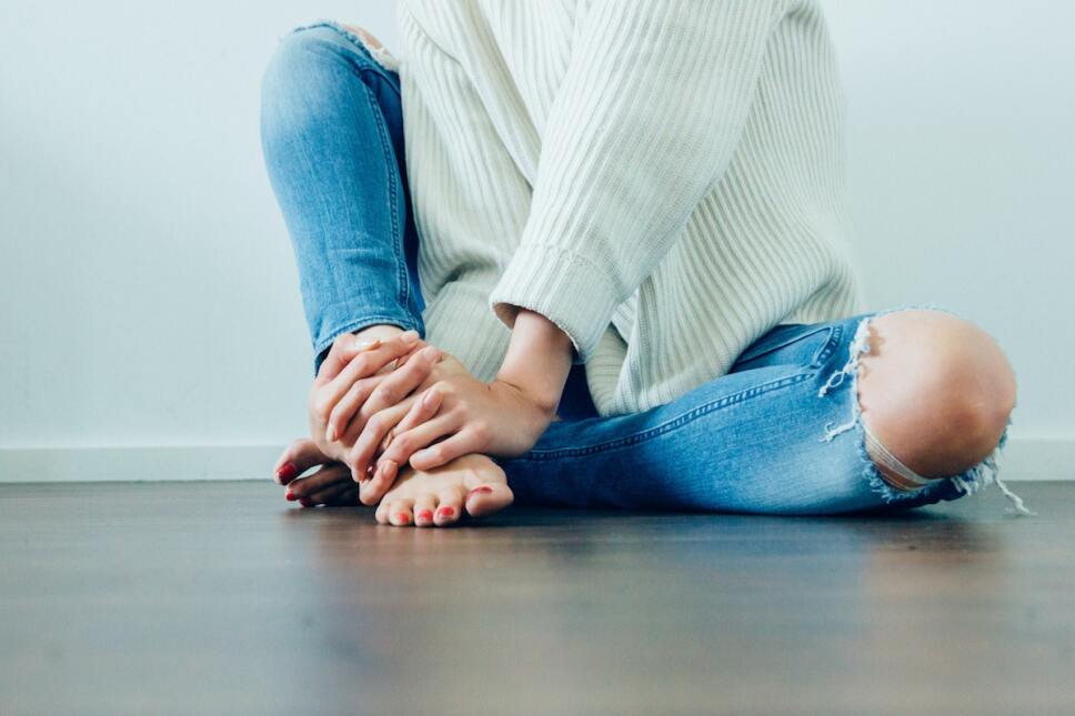 mujer sosteniendo su tobillo con dolor
