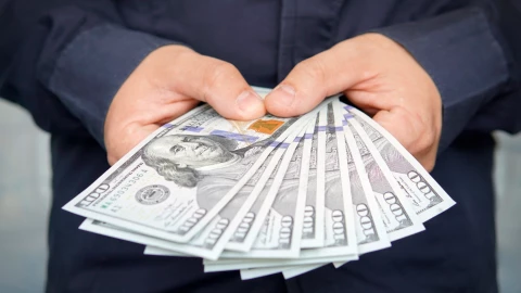 un hombre contando dólares con sus manos