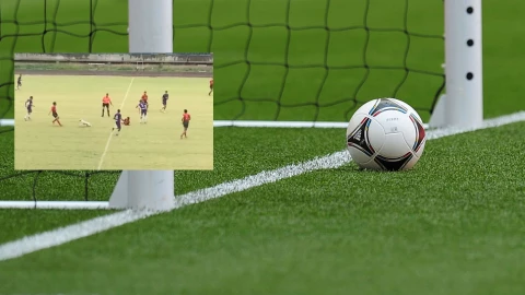 Cancha de futbol con un balón sobre la líinea
