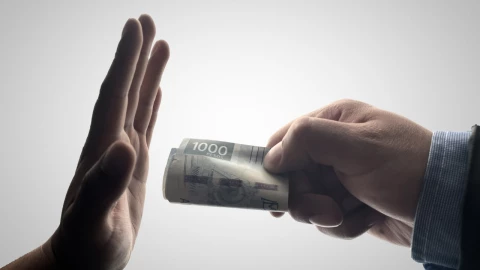 Foto de persona dando dinero a otra.