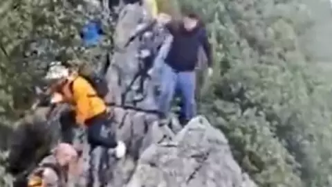 TURISTA CAE al vacío durante intento de tomarse una FOTO en una montaña; así captaron el momento exacto