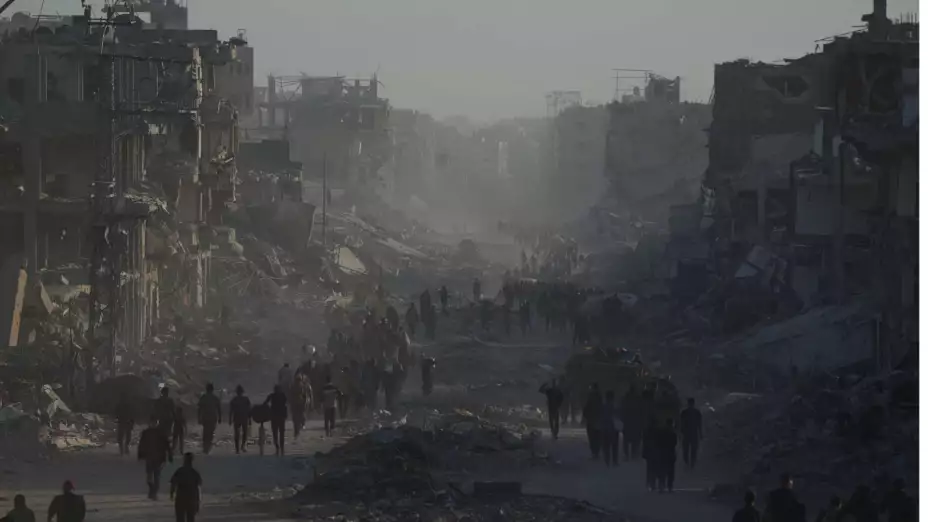 Palestinos desplazados caminan entre ruinas en la Ciudad de Gaza.