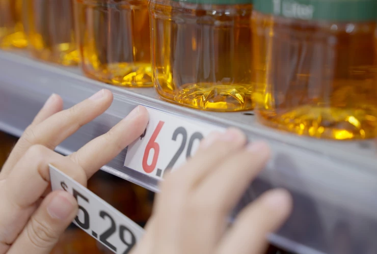 Empleada de un supermercado coloca nuevo precio a un producto