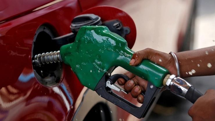 Persona llena el tanque de un auto con gasolina Regular
