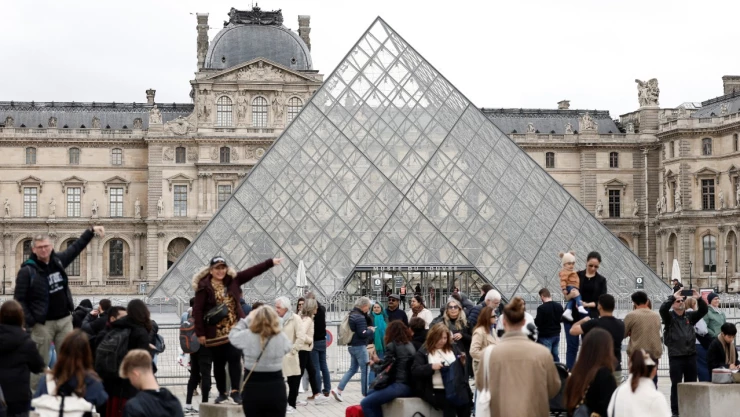 Foto de turistas a las afueras del Museo del Louvre en París, Francia.