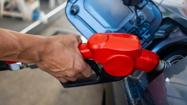 hombre carga el tanque de gasolina de su vehículo