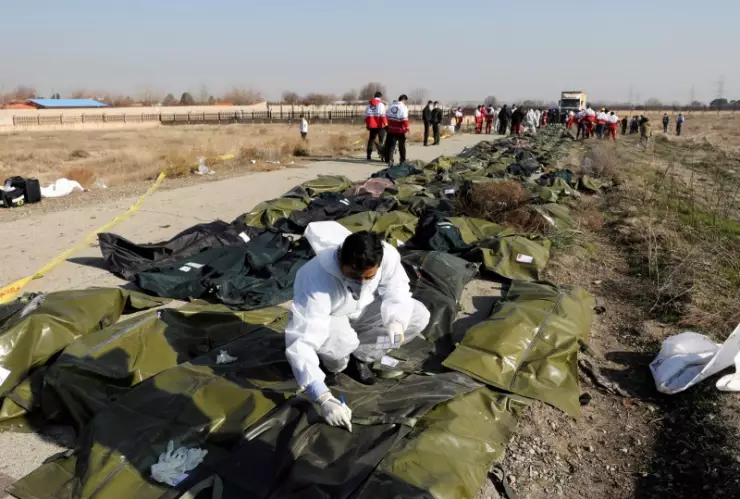 Cuerpos de pasajeros en bolsas de plástico en el sitio donde el avión de Ukraine International Airlines se estrelló después del despegue del aeropuerto iraní Imán Jomeini, en las afueras de Teherán.