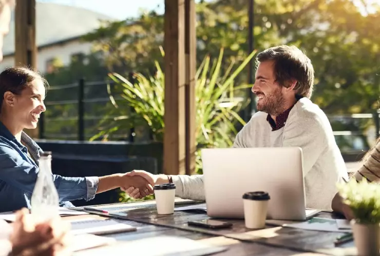 un grupo de gente trabaja felizmente en equipo