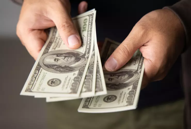 Una persona cuenta dólares estadounidenses