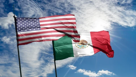 Las banderas de Estados Unidos y México flameando