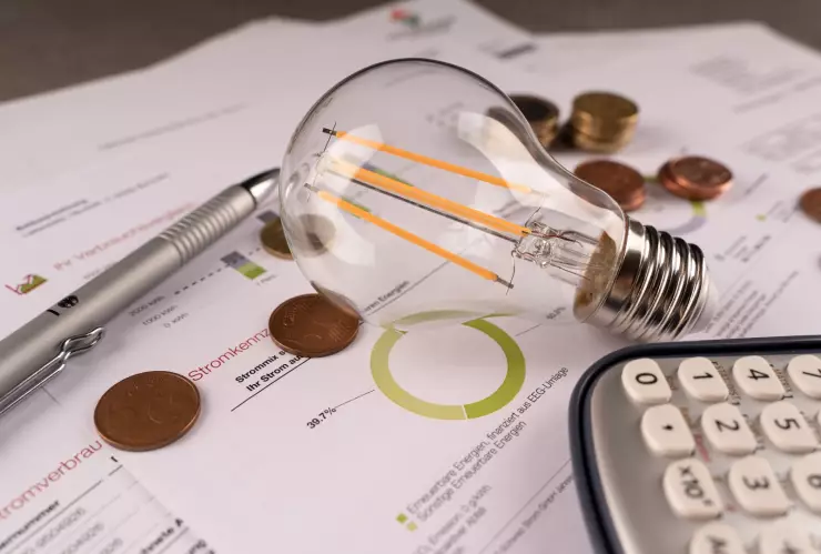 Una factura de luz junto a calculadora y monedas
