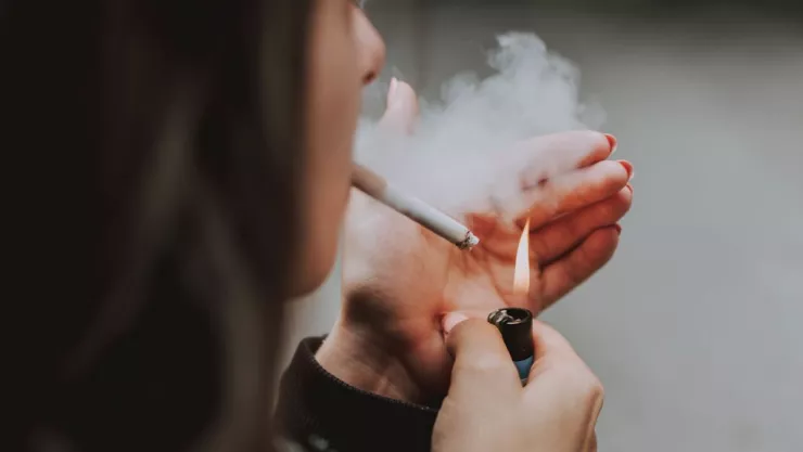 Mujer fumando en la calle