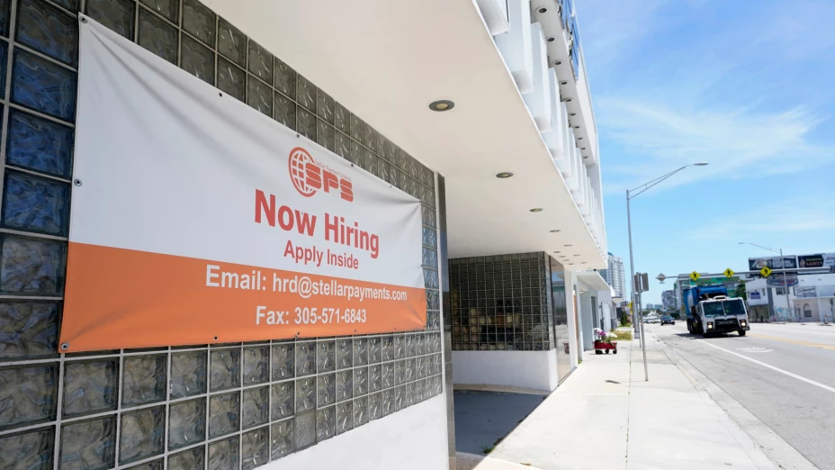 Aviso de vacantes laborales afuera de un negocio en Miami