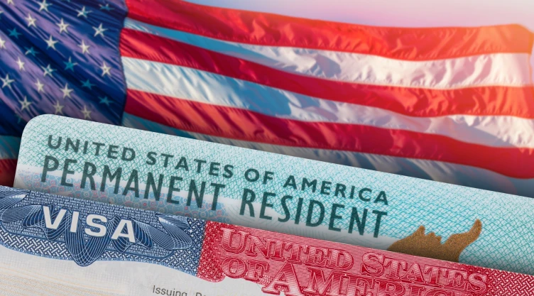 Una bandera americana bajo una tarjeta de residencia permanente en Estados Unidos