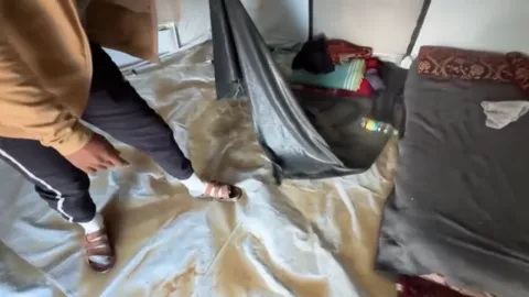 Un hombre palestino muestra el interior de su casa de campaña inundada en la Franja de Gaza