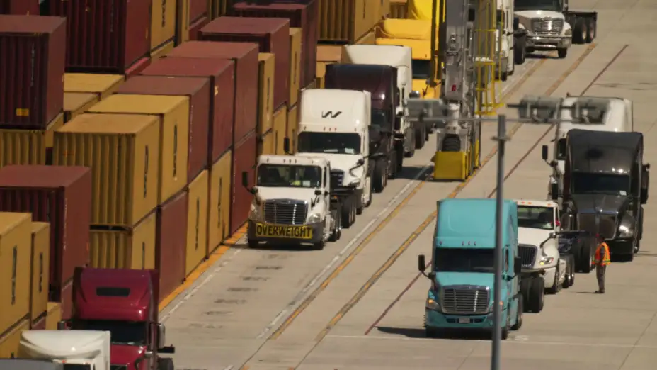 Camiones esperan para cargar contenedores en el puerto de Los Ángeles.