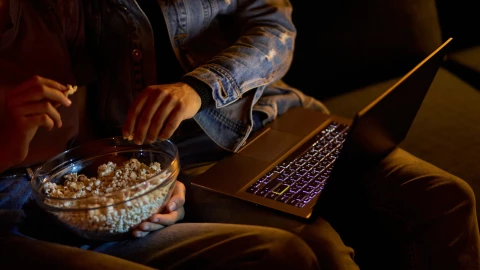 una pareja mira una película mientras comen palomitas