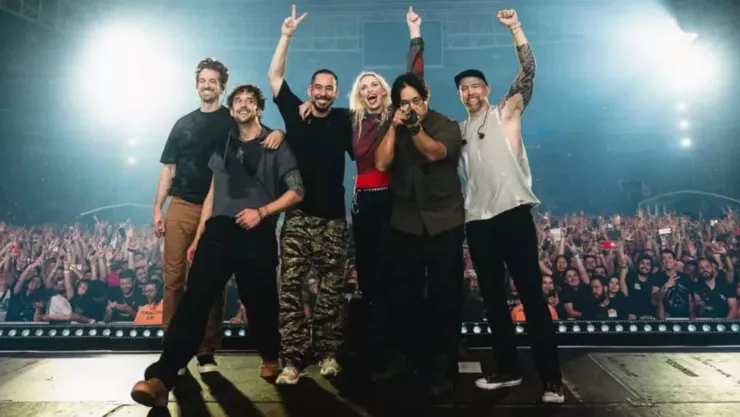 Músicos de la banda Linkin Park posando para tomarse foto con el publico de fondo después de un concierto desde el escenario